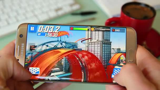 Человек, играющий в видеоигру на своем смартфоне в офисе — стоковое видео