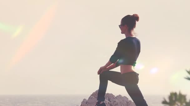 Молода жінка силует йога на пляжі на заході сонця — стокове відео