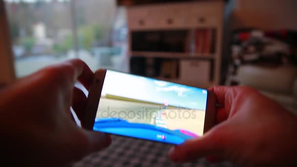 Uomo che gioca un videogioco sul suo smartphone a casa — Video Stock