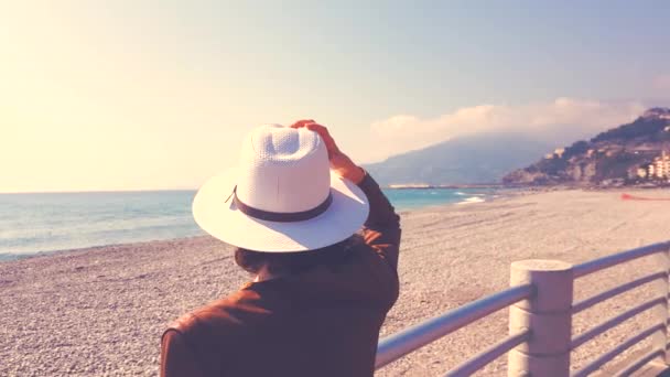 Mujer con sombrero mirando al mar — Vídeo de stock