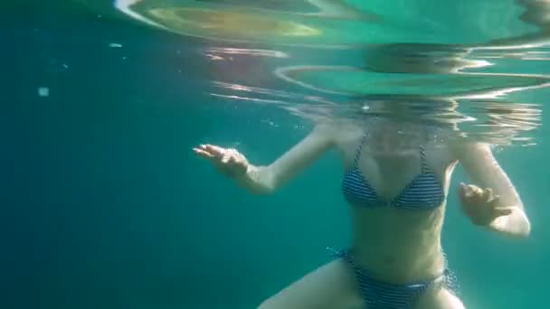 Hermosa mujer joven en bikini nadando bajo el agua en mar cristalino — Vídeo de stock