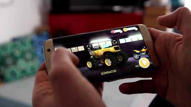 2018年1月17日 人玩黄金峰 A25 应用程序 赛车在他的现代智能手机三星银河 边缘在家里的视频游戏 — 图库视频影像