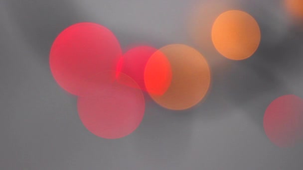 美しい赤とオレンジのラウンドのライトがぼやけています 灰色の背景のボケ味の粒子 抽象化された運動の背景 — ストック動画