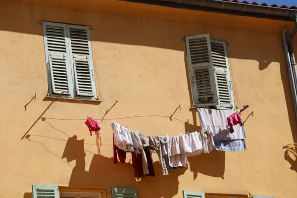 Séchage des vêtements de blanchisserie suspendus devant la fenêtre en France — Photo