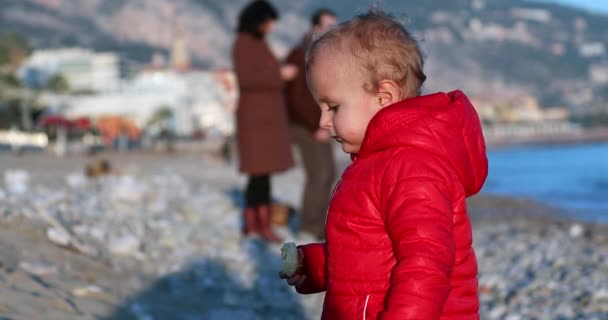 Χαριτωμένο Ξανθό Αγοράκι Δύο Ετών Ένα Κόκκινο Μπουφάν Τρώει Ένα — Αρχείο Βίντεο