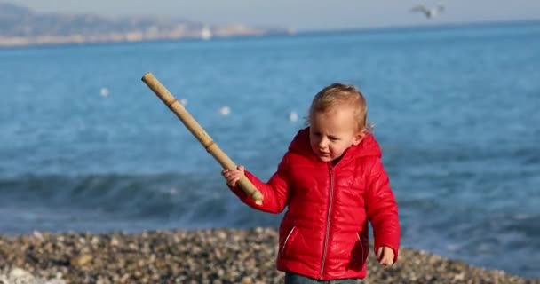 法国里维拉 地中海 一个可爱的金发男婴在海滩上玩竹竿的肖像 一个穿着红色羽衣的两岁男孩 Dci — 图库视频影像