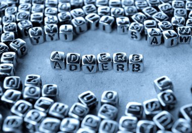 Adverb - Word from Metal Blocks on Paper - Concept Photo on Table clipart
