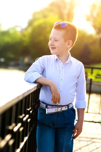 Stylish baby boy with ginger hair in trendy sunglasses