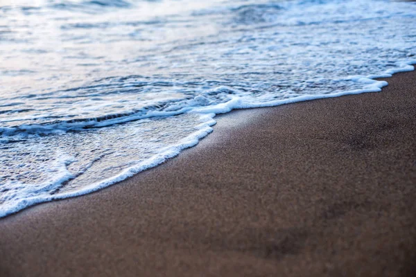 Sandstrand und Welle im Sonnenuntergang — Stockfoto