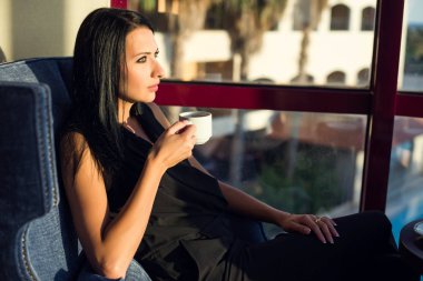 Güzel esmer kadın içki kahve güneş ışığı altında