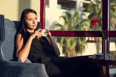 Güzel esmer kadın içki kahve güneş ışığı altında