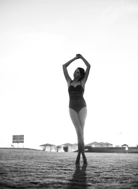 Bikini günbatımı üzerinde yeşil çimenlerin üzerinde mutlu güzel kadın.