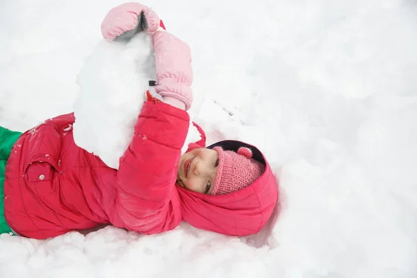 Παιχνιδιάρικο κορίτσι με πλεξούδες παίζοντας στο πρώτο χιόνι — Φωτογραφία Αρχείου