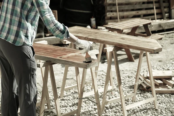 Trabajador aplicando pintura de tratamiento de madera fresca — Foto de Stock