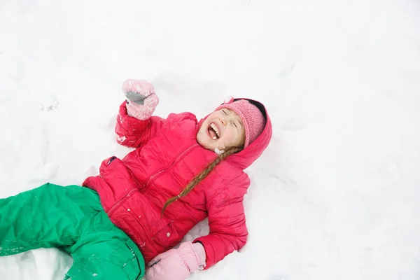 Hravá dívka s copánky hraje v prvním sněhu — Stock fotografie