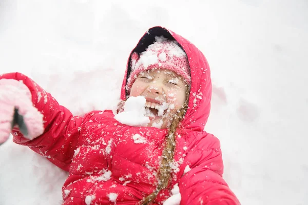 Παιχνιδιάρικο κορίτσι με πλεξούδες παίζοντας στο πρώτο χιόνι — Φωτογραφία Αρχείου