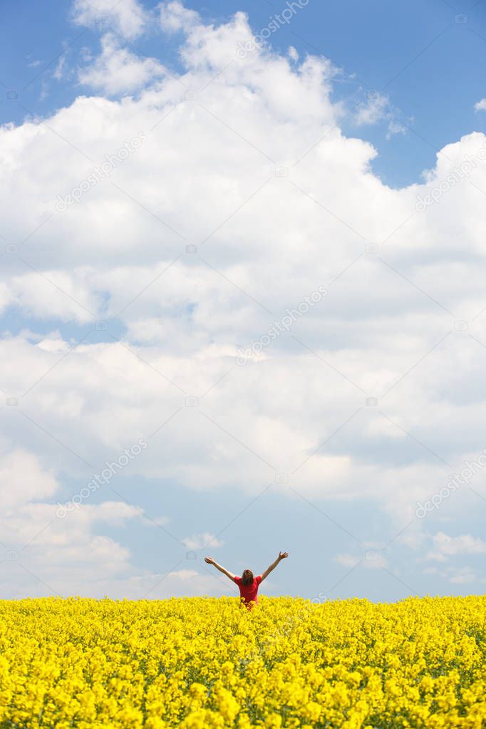 Woman with arms raised high, enjoying freedom