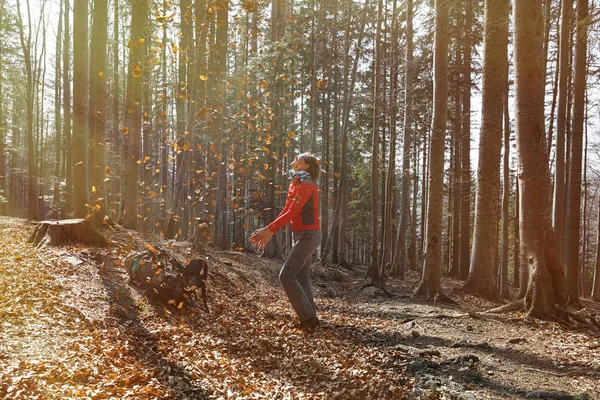 Fit woman hiker enjoying the nature, throwing leaves — Stock Photo, Image