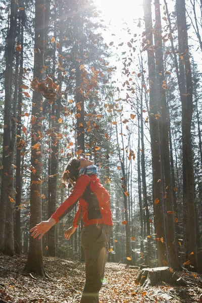 Fitte Wanderin genießt die Natur, wirft Blätter — Stockfoto