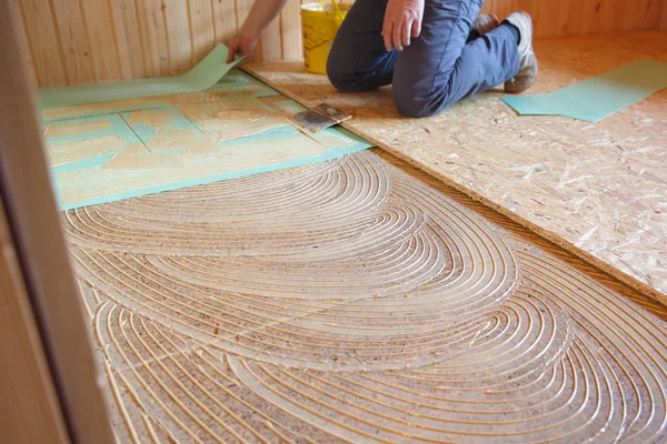 Worker laying insulation layer and spreading adhesive primer — Stock Photo, Image