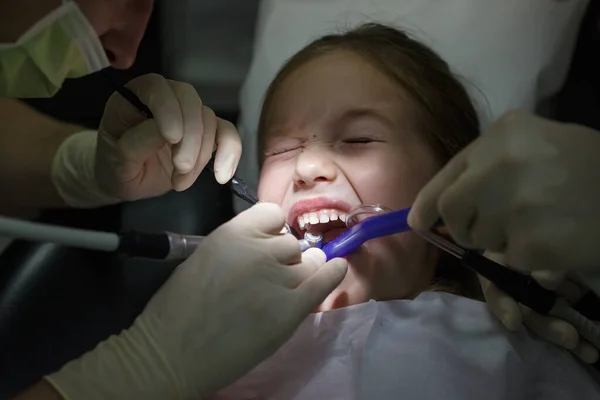 Niña asustada en el consultorio de dentistas, con dolor durante un tratamiento . —  Fotos de Stock