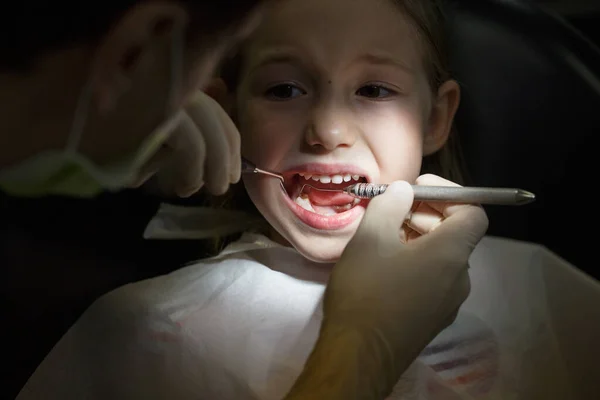 Niña asustada en el consultorio de dentistas, con dolor durante un tratamiento . —  Fotos de Stock