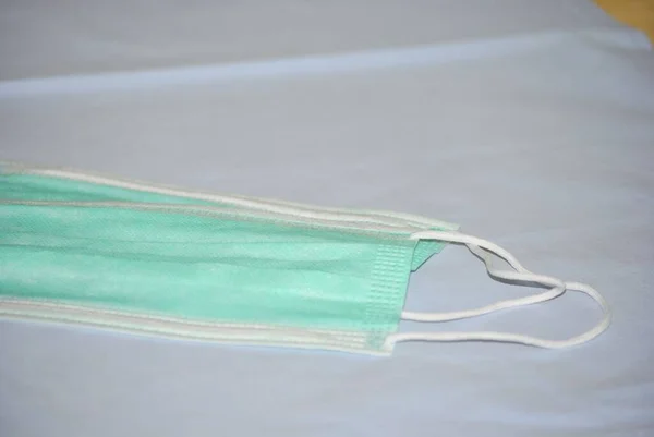 Mavi tekstil arka planında iki cerrahi maske