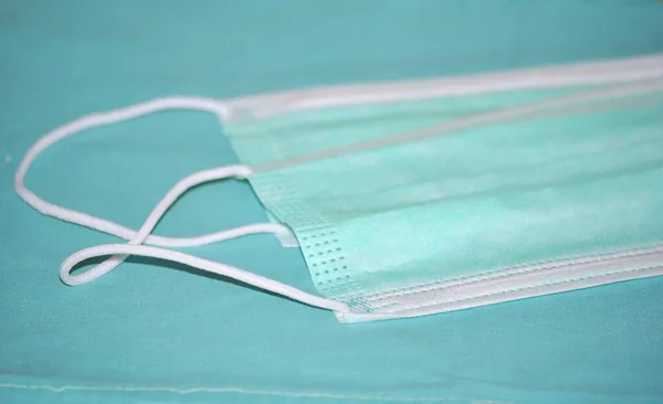 Mavi tekstil arka planında iki cerrahi maske