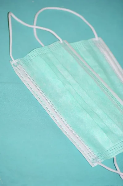 Mavi tekstil arka planında iki cerrahi maske