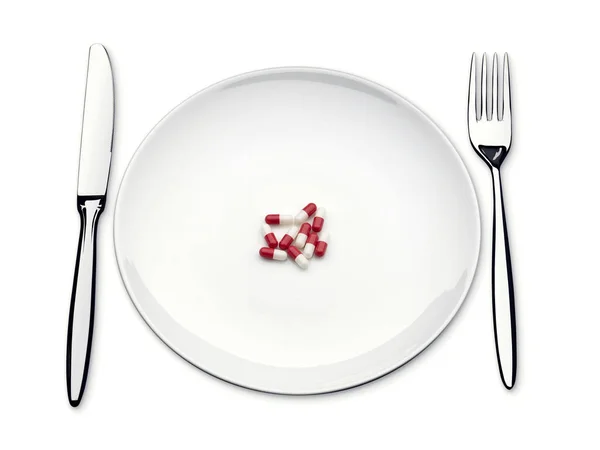 Таблетки на пустой тарелке с ножом и вилкой Стоковое Фото