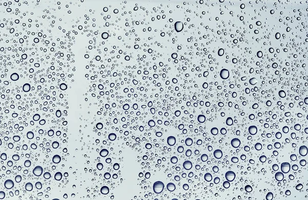 Wassertropfen vor einem Fenster auf weißem Hintergrund. — Stockfoto