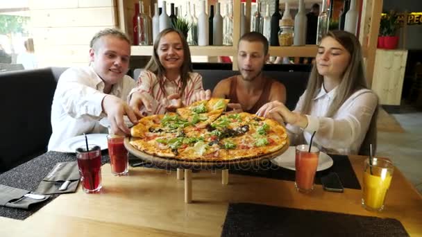 Personer som tar pizza nedskärningar från plattan på bord. — Stockvideo