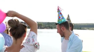 Göl özgeçmişlerine sabun köpüğü üfleme insanların genç groupe arka görünümü.