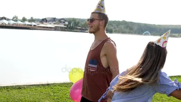 Young couple blowing soap-bubbles on the lake background. — Stock Video