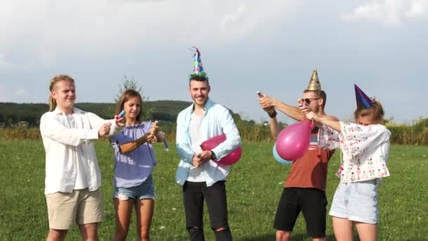 Jonge groupe mensen blazen van zeepbellen op de camping. — Stockvideo