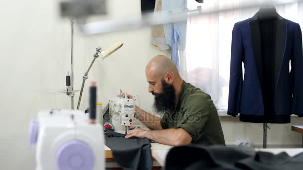 Een kleermaker in een workshop naaien op het werk. — Stockvideo