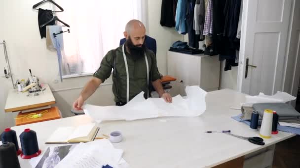 Tailor trabaja con bocetos en su taller . — Vídeo de stock