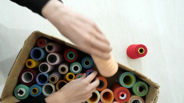 Top view. Hands takes multi-colored spolls from the box. — Stock Video