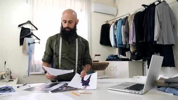 Tailor works with sketches in his workshop. — Stock Video