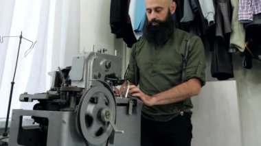 Bir terzi deliği ilik makinesinde çalışır.