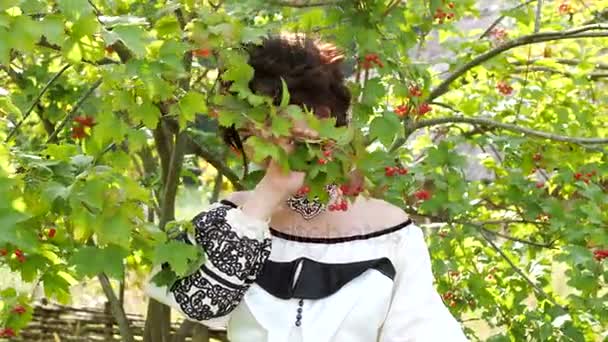 Schoonheid Oekraïense meisje buiten genieten van een tak van de guelder-rose. — Stockvideo