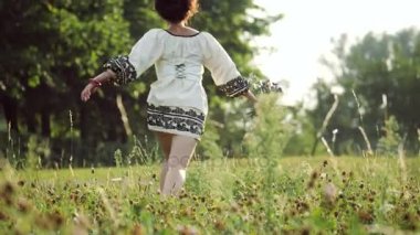 Arkadan Görünüm. Çayır pembe yonca bir arka plan üzerinde çalışan kız