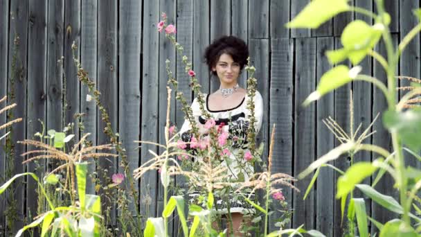 Ukrajinská dívka stojí na pozadí stodoly. — Stock video