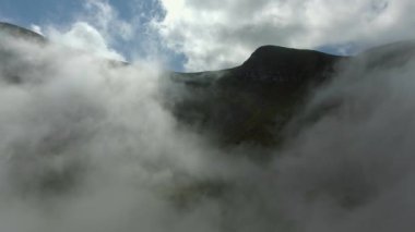 Havadan görünümü. Yüksek dağların güzel bulutların üzerinden uçan.