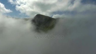Havadan görünümü. Yüksek dağların güzel bulutların üzerinden uçan.