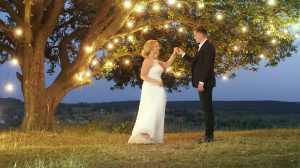 Pareja joven enamorada en vestidos de noche están bailando sobre la naturaleza . — Vídeos de Stock