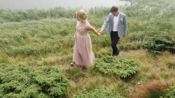 Verliefde paar lopen op het bospad in de buurt van het meer. — Stockvideo