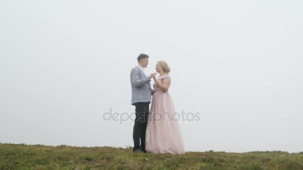 Luxury couple in evening dresses are hugging and kissing on the mountain meadow — Stock Video