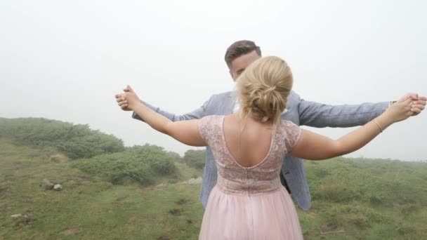 The couple walk on the mountain meadow and hug. — Stock Video