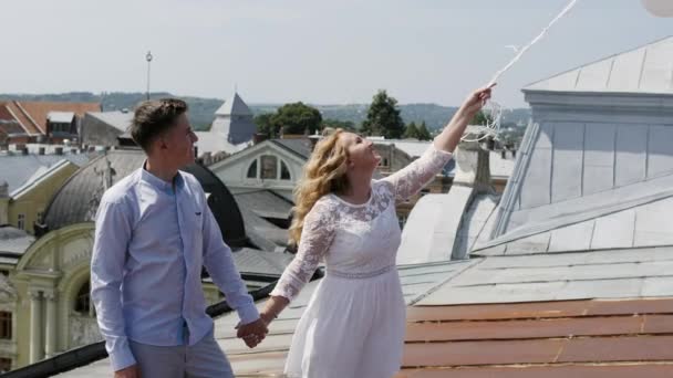 Casal segurando alguns balões no telhado . — Vídeo de Stock